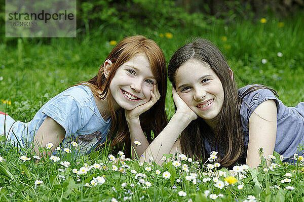 Mädchen liegen auf einer Blumenwiese