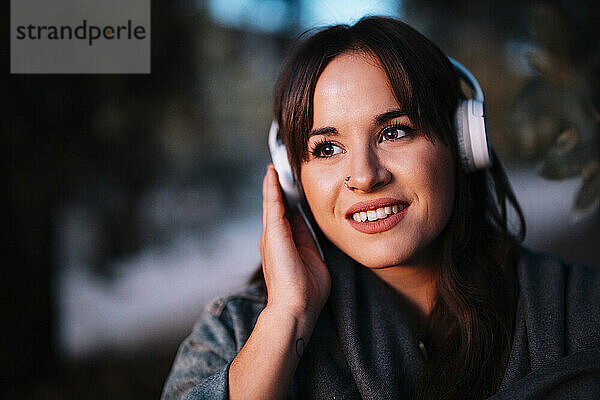Attraktive Frau hört Musik über Kopfhörer im Wald