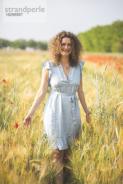 Lächelnde junge Frau erkundet landwirtschaftliches Feld