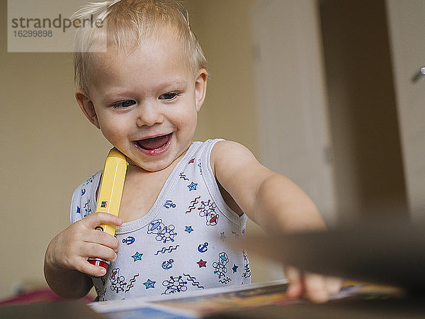 Nettes glückliches Baby spielt mit Bleistift zu Hause
