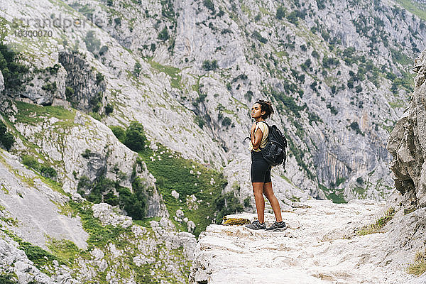 Frau mit Rucksack bewundert die Aussicht  während sie auf einem Bergpfad an der Ruta Del Cares steht  Asturien  Spanien