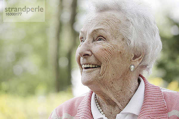Deutschland  Nordrhein-Westfalen  Köln  Ältere Frau schaut weg  lächelnd