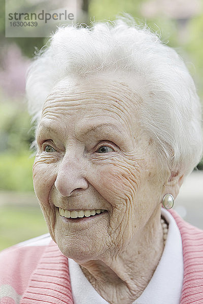 Deutschland  Nordrhein-Westfalen  Köln  Ältere Frau schaut weg  lächelnd