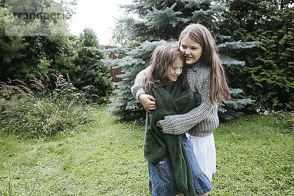 Schwestern umarmen sich im Hinterhof