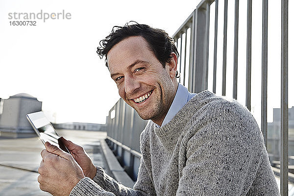 Porträt eines lächelnden Mannes mit Tablet-Computer