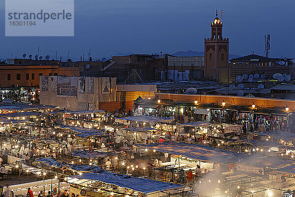 Marokko  Marrakesch  Menschen auf dem Djemaa el Fna Platz mit der Koutoubia Moschee bei Nacht