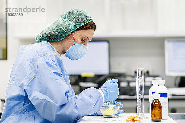 Apothekerin bei der Zubereitung von Medikamenten im Mörser auf einem Tisch im Labor