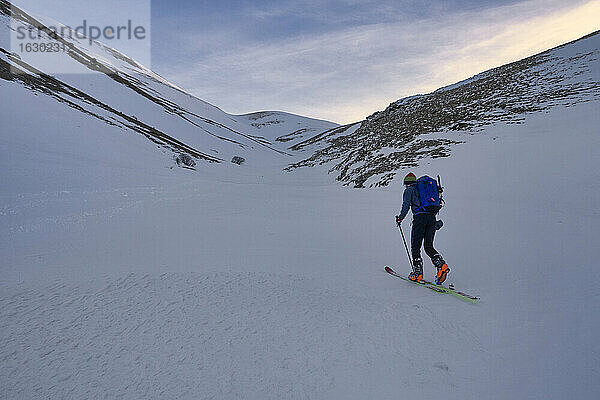 Junger Mann beim Skilanglauf auf dem Berg Sibillini bei Sonnenuntergang  Umbrien  Italien
