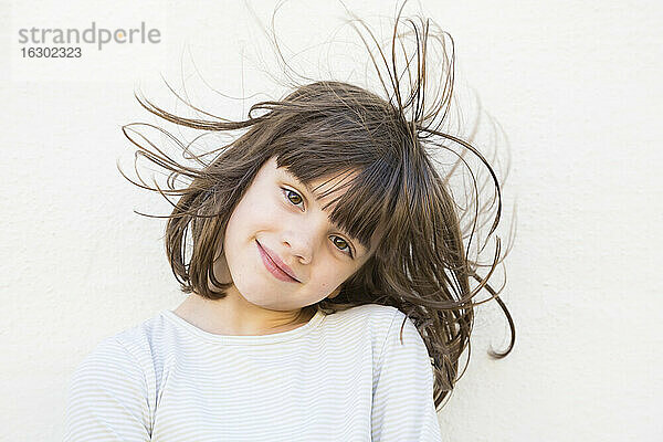 Porträt eines lächelnden kleinen Mädchens mit wehendem Haar