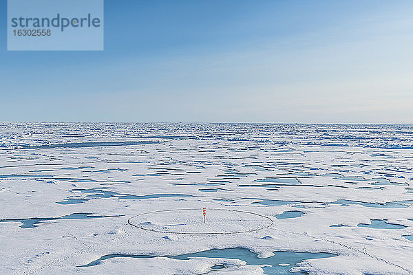 Luftaufnahme einer runden Markierung  die auf dem schmelzenden Eis des Nordpols aufgestellt wurde