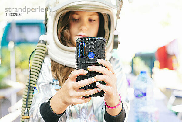 Nahaufnahme eines Mädchens im Raumanzug  das ein Selfie mit einem Smartphone macht