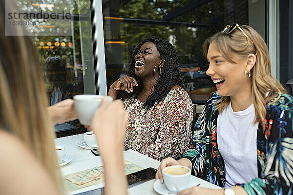 Glückliche Freundinnen treffen sich in einem Cafe
