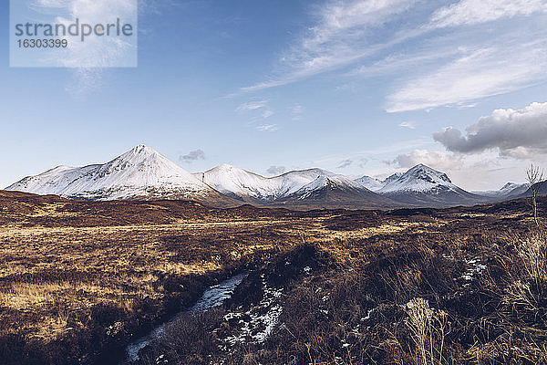 UK  Schottland  Flusslauf auf der Isle of Skye im Winter mit schneebedeckten Bergen im Hintergrund