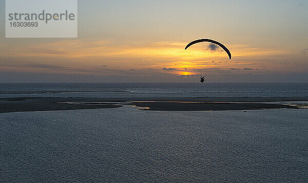 Frankreich  Aquitanien  Gironde  Pyla sur Mer  Dune du Pilat  Gleitschirmflieger über dem Atlantik bei Sonnenuntergang