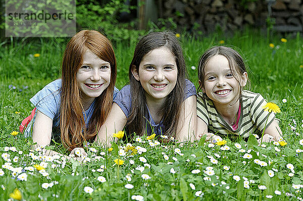 Mädchen liegen auf einer Blumenwiese