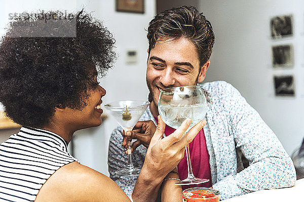 Nahaufnahme eines glücklichen Paares  das sich beim Trinken von Cocktails in einer Bar ansieht