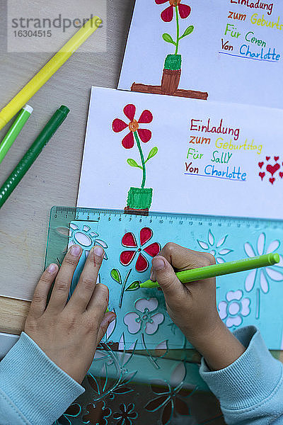 Cropped Bild von Mädchen Hände Zeichnung Blumen auf Papiere am Tisch