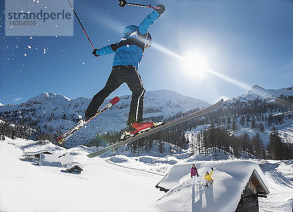 Österreich  Salzburg  Junger Mann beim Skispringen in den Bergen