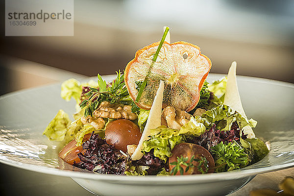 Teller mit gemischtem Salat mit Walnüssen  Tomaten und Parmesan