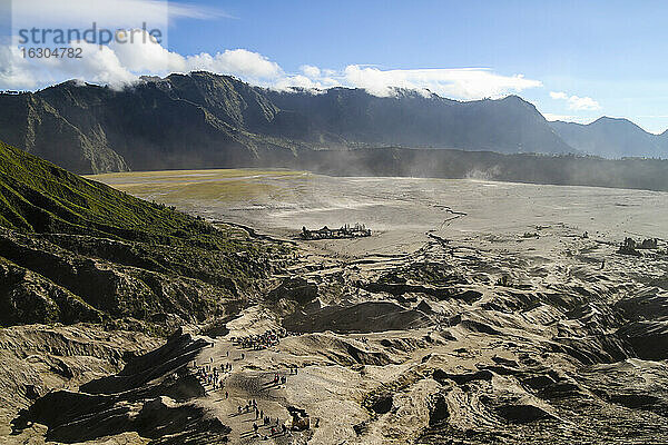 Indonesien  Java  Bromo Tengger Semeru National Park  Touristen auf dem Weg zum Vulkan Mount Bromo  im Hintergrund der Pura Luhur Poten Hindu-Tempel