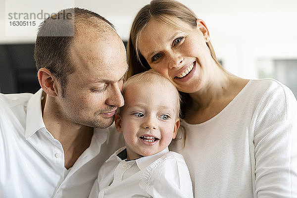 Lächelnde Eltern mit einem kleinen Jungen zu Hause