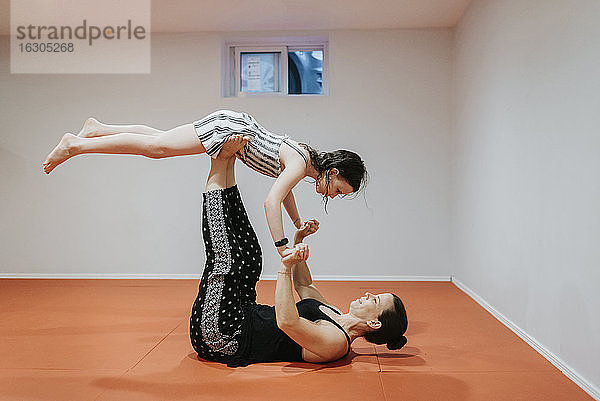 Mutter und Tochter machen Akrobatik im Keller