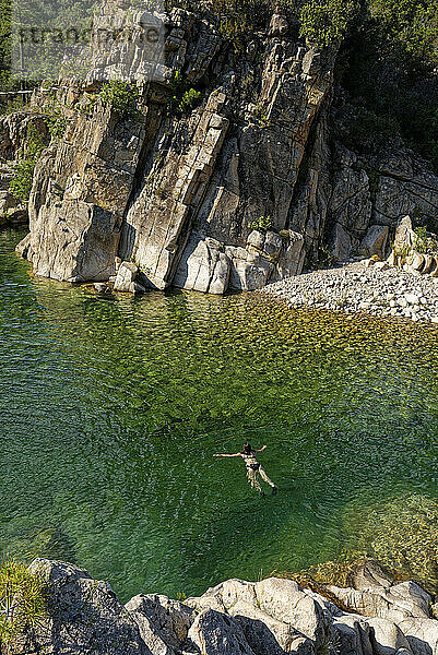 Frau schwimmt im Fluss Solenzara