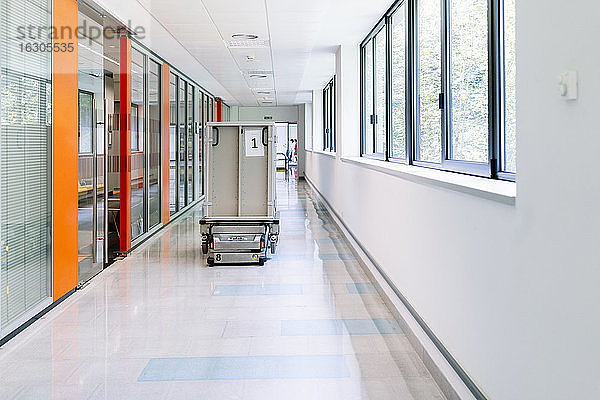 Roboterwagen mit Metallbehälter  der sich im Krankenhausflur bewegt