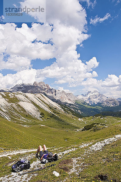 Italien  Südtirol  Dolomiten  Naturpark Fanes-Sennes-Prags  Wanderer liegend auf Almwiese