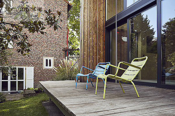 Leere Stühle auf Hartholzboden vor kleinem Haus