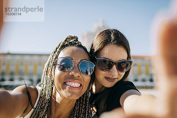 Lächelnde Frau macht ein Selfie mit einem Freund am Praca Do Comercio  Lissabon  Portugal