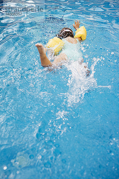 Kleines Mädchen taucht im Schwimmbad