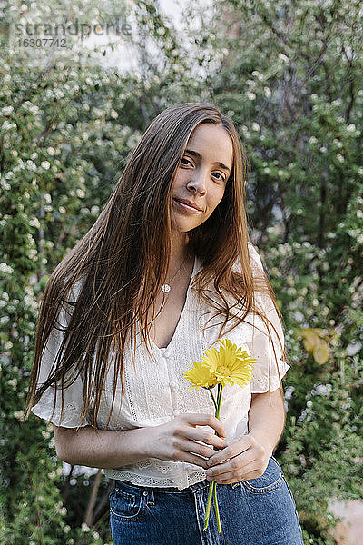 Junge Frau hält gelbe Blumen im Frühling