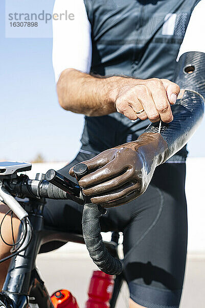 Nahaufnahme eines männlichen Radfahrers mit künstlicher Hand auf dem Fahrrad