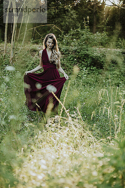 Schöne Frau geht auf Gras im Wald