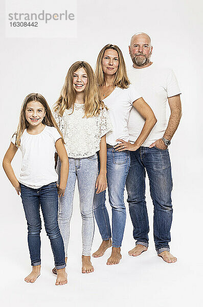 Eltern mit Töchtern stehend vor weißem Hintergrund