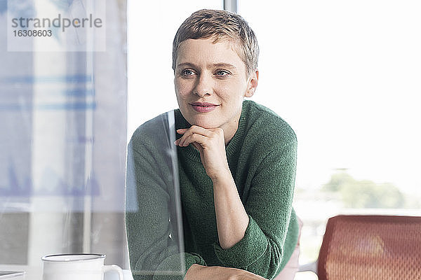 Geschäftsfrau im Büro mit Blick auf einen virtuellen Bildschirm