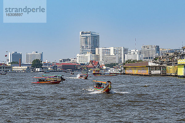 Thailand  Bangkok  Fähren auf dem Fluss Chao Phraya mit der Skyline der Stadt im Hintergrund