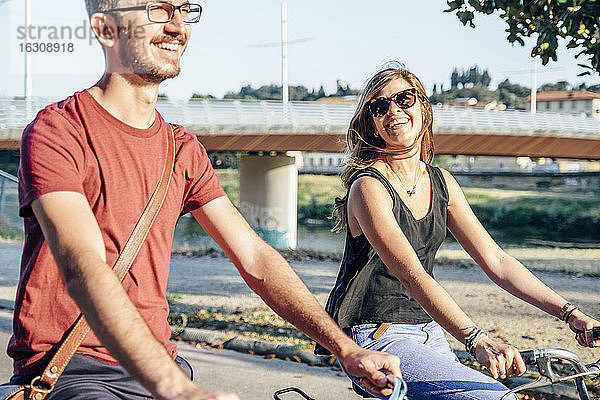 Fröhliches Paar beim Fahrradfahren im Park an einem sonnigen Tag am Wochenende
