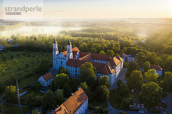 Deutschland  Bayern  Irsee  Blick aus dem Hubschrauber auf das Kloster Irsee bei nebligem Morgengrauen