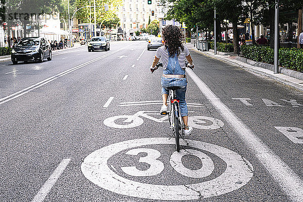 Ältere Frau fährt auf dem Fahrradweg in der Stadt
