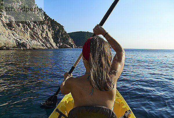 Frau im Kajak sitzend im Boot gegen den klaren Himmel