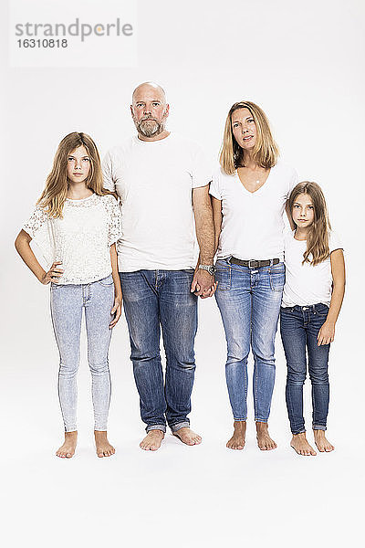 Familie in T-Shirts und Jeans vor weißem Hintergrund