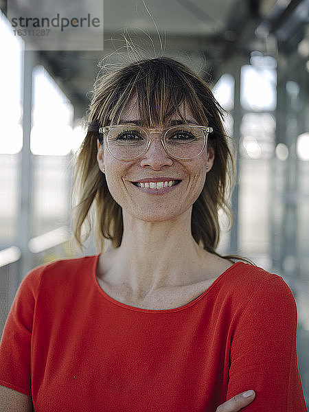 Nahaufnahme einer lächelnden Geschäftsfrau mit Brille im Gewächshaus
