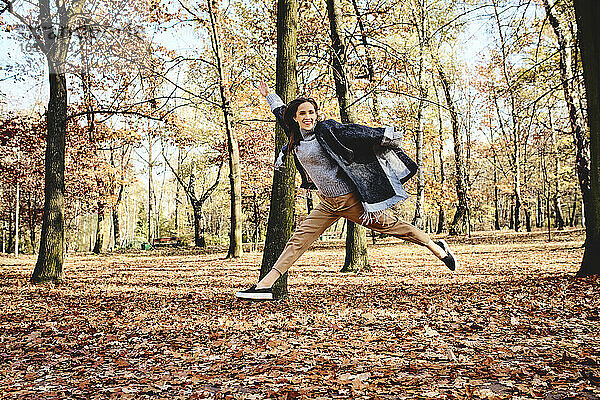 Junge Frau springt im Herbstwald