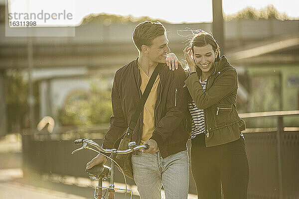 Glückliches Paar mit Fahrrad auf der Straße an einem sonnigen Tag