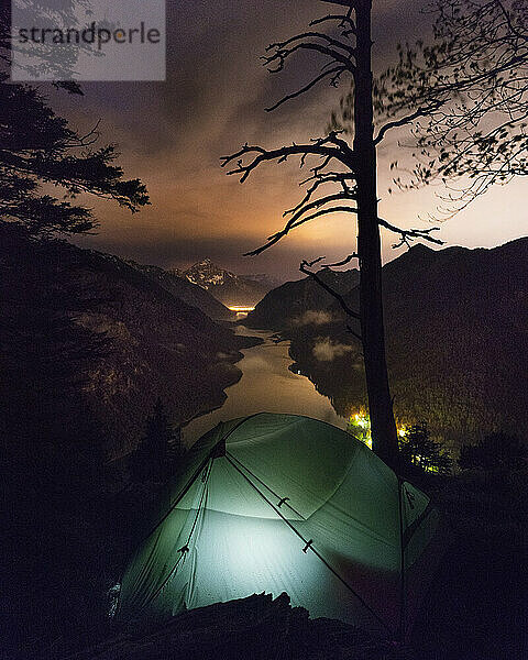 Beleuchtetes Zelt am Rande des Plansees bei Nacht