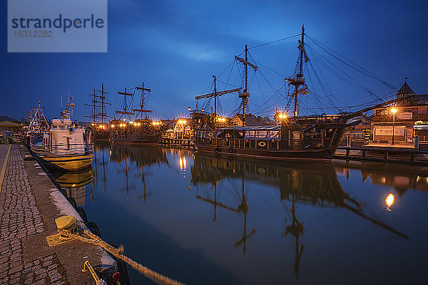 Polen  Pommern  Leba  Historische Großschiffe  die in der Abenddämmerung im Hafen festgemacht haben