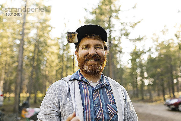 Porträt eines lächelnden Mannes mit gebratenem Marshmallow am Stock  Wasatch Cache National Forest