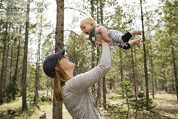 Lächelnde Frau spielt mit ihrem kleinen Sohn (6-11 Monate) im Wald  Wasatch-Cache National Forest